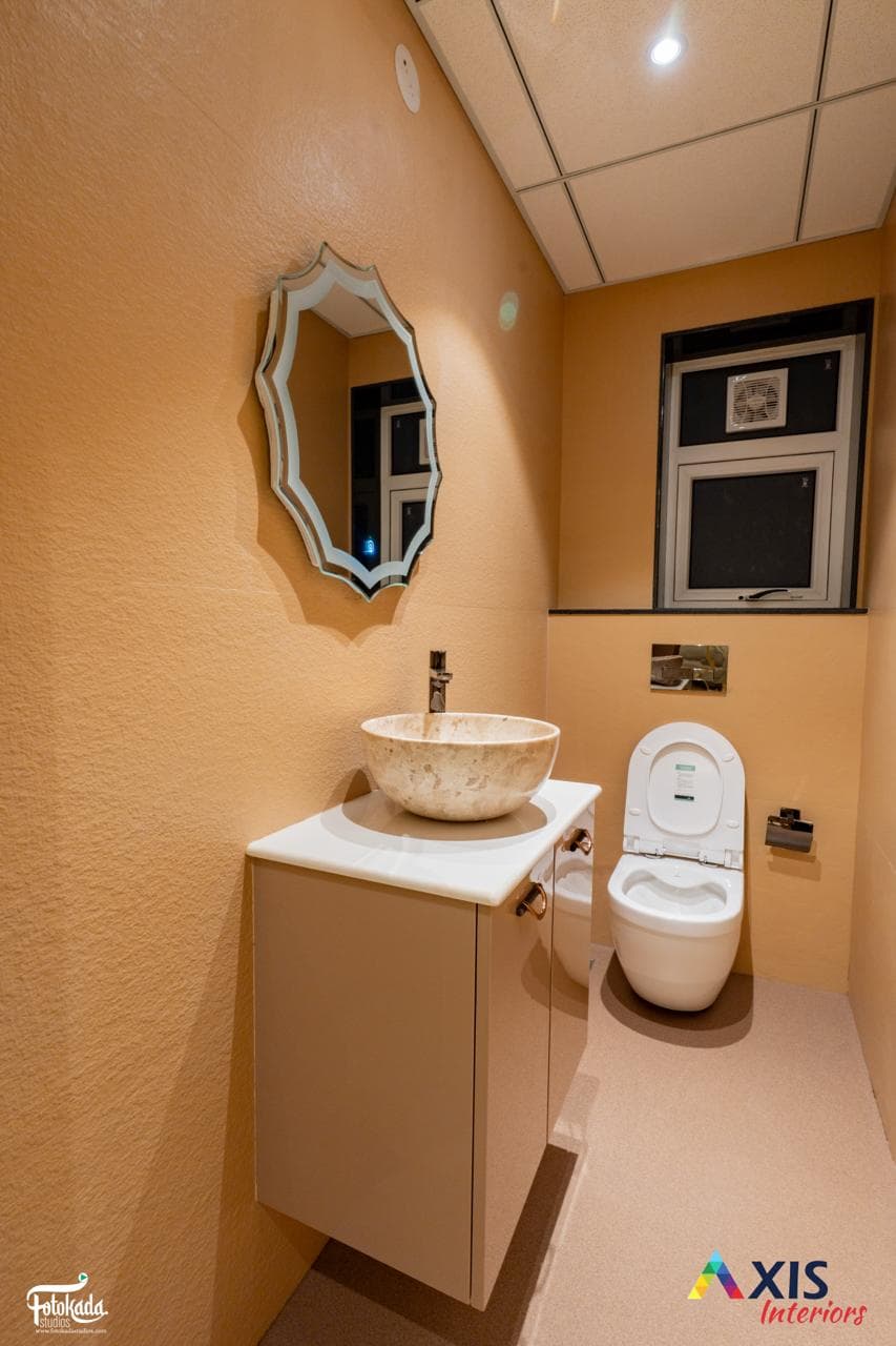 Designer washroom with stone vessel basin and ornate mirror